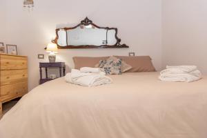 una camera da letto con un letto e asciugamani di [Centro Storico] Redmood House a 5 min dal mare, Wi-Fi, A/C e Netflix a Barletta
