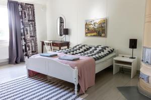 - une chambre avec un lit, une table et un miroir dans l'établissement Villa Korkatti, à Haapavesi