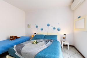 a bedroom with two beds with blue sheets at SORRIDI AL LAGO in Sirmione