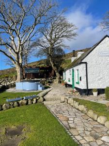 a stone path next to a white building at Carrick Cottage - Mourne Mountains in Annalong