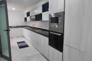 uma cozinha com um micro-ondas e um fogão em Luxe Modern 3 BR City Center TNGR w. Superfast Wifi & AC em Tânger