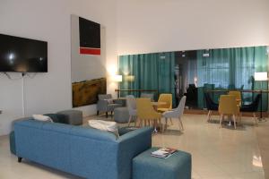 a living room with a blue couch and chairs at Hotel Francis in Beja