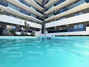 a swimming pool in front of a building at Azul Sunrise in Mamaia Sat/Năvodari