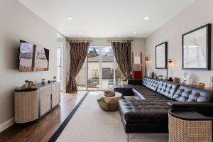 a living room with a leather couch and a large window at Luxury Home: Monthly Rental House Near Denver in Englewood