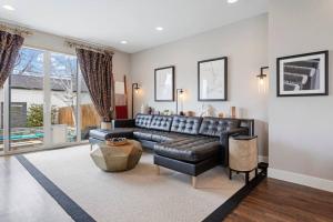 a living room with a black leather couch at Luxury Home: Monthly Rental House Near Denver in Englewood