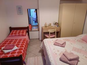 a small bedroom with two beds and a desk at Apartment in green and quite area, close to beach in Šilo
