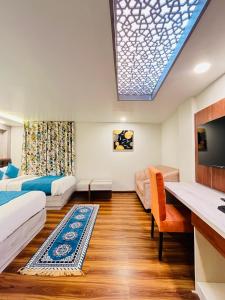 Habitación con 2 camas, TV y sofá. en Goroomgo Broadway Boutique Mall Road Darjeeling - Luxury Stay - Best Seller en Darjeeling