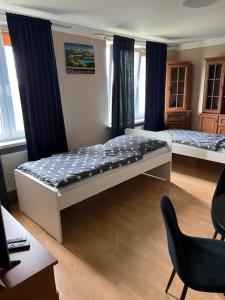 a bedroom with two beds and a desk and chairs at Mieszkaj U Marty in Jaworzno