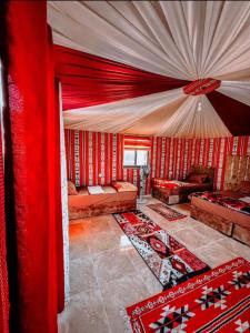 a living room with red walls and red curtains at Rum Mars camp in Wadi Rum