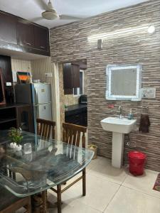eine Küche mit einem Glastisch und einem Waschbecken in der Unterkunft Chandigarh Housing Board Flats Sector 44 D in Chandīgarh