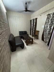 ein Wohnzimmer mit einem Sofa und einem Tisch in der Unterkunft Chandigarh Housing Board Flats Sector 44 D in Chandīgarh