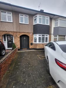 a white car parked in front of a house at Spacious Newly Renovated Three Bedroom House with private parking in Rainham