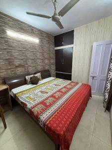 a bed in a room with a ceiling fan at Chandigarh Housing Board Flats Sector 44 D in Chandīgarh
