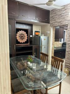 a kitchen with a glass table and a refrigerator at Chandigarh Housing Board Flats Sector 44 D in Chandīgarh
