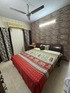 ein Schlafzimmer mit einem großen Bett mit einer roten Decke in der Unterkunft Chandigarh Housing Board Flats Sector 44 D in Chandīgarh