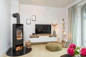 a living room with a fireplace and a tv at Alte Waescherei _9463_ in List