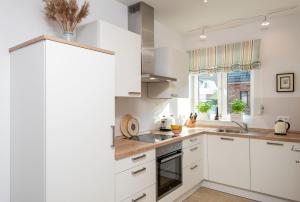 a kitchen with white cabinets and a sink at Alte Waescherei _9463_ in List