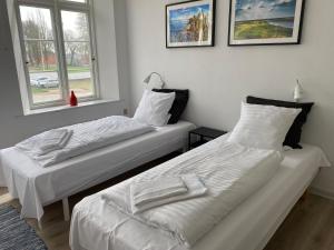 two beds sitting next to each other in a room at Marsk Hotel Apartments 6B, 1 - TV in Højer