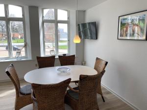 una sala da pranzo con tavolo e sedie bianchi di Marsk Hotel Apartments a Højer