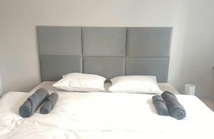1 cama blanca con 2 almohadas y 3 mantas grises en Matylda House en Cracovia