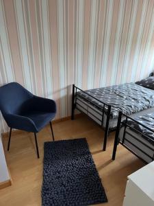 a room with a bed and a chair and a rug at Mieszkaj U Marty in Jaworzno