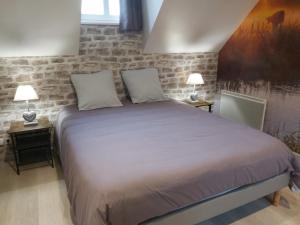 a bedroom with a large bed with two lamps at le bonheur des plumes in Montmartin-en-Graignes