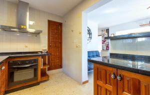 een keuken met houten kasten en een fornuis met oven bij 2 Bedroom Lovely Home In Orba in Orba