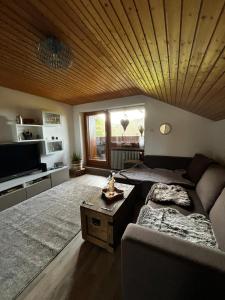 a living room with a couch and a table at Sonnen-Juwel mit Pool - Sauna direkt an der Skipiste in Missen-Wilhams