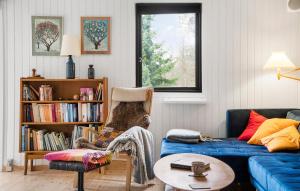 een woonkamer met een blauwe bank en een boekenplank bij Beautiful Home In Vig With Wifi in Vig