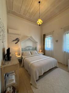 a bedroom with a large bed and a television at Alacati Zeynep in Alaçatı