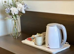 a tea kettle and cups on a table with a vase at Villa Azzurra in Lampedusa
