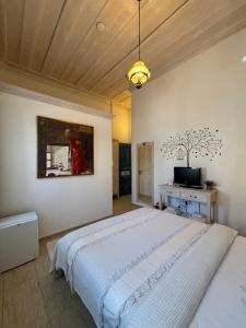 a bedroom with a large bed and a television at Alacati Zeynep in Alacati
