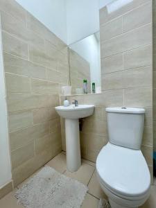 a bathroom with a toilet and a sink at Homestay-Close to Coventry City and University I Free Parking I Wi-Fi in Coventry