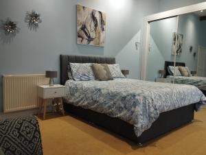a bedroom with a bed and a mirror at Private Quay, Balcony, Sea Views, Free Parking in Pembrokeshire