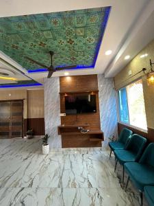 a lobby with blue chairs and a flat screen tv at PAGDANDI VILLA BY ALOHA in Udaipur