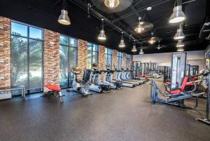 a gym with rows of treadmills and machines at New Luxury Townhome, Stay close in style! in Davenport