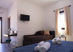 a living room with a couch and a bed with towels at Villa Azzurra in Lampedusa