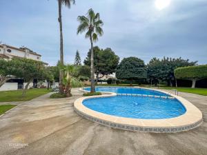 a swimming pool in a park with palm trees at Casa El Grande in Torrevieja