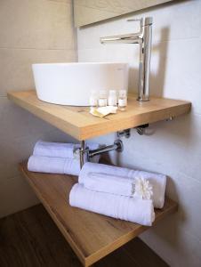 a sink and towels on a wooden shelf in a bathroom at Villa Azzurra in Lampedusa +35 photos