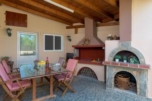 a patio with a table and a fireplace at Villa Vera in Paradeísion