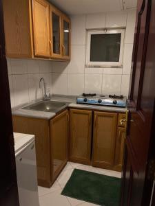 uma pequena cozinha com um lavatório e um fogão em أجنحة أبو قبع الفندقيةAbu Quboh Hotel Suite Apartment em Amã