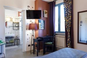 a bedroom with a bed and a desk and a bathroom at Ca' Bianca B&B in Fosdinovo