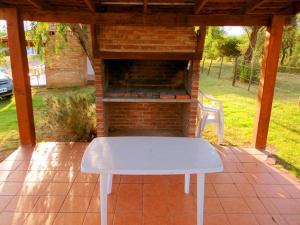 a white bench sitting in front of a brick oven at Lomas de Belgrano in Villa General Belgrano
