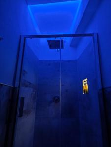 a bathroom with a glass shower with a blue ceiling at Loft 21 in Empoli