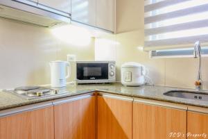 a kitchen with a sink and a microwave at 56sqm. Condo at Mactan Newtown w/Free Beach and Pool Access! in Lapu Lapu City