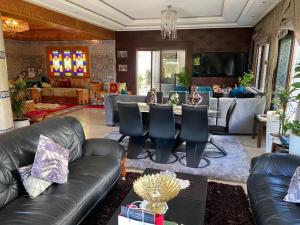 sala de estar con sofás de cuero y mesa en فيلا للاستمتاع, en El Harhoura