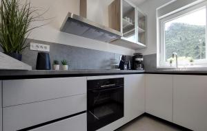 uma cozinha com armários brancos e um forno preto em 2 Bedroom Beautiful Apartment In Plomin Luka em Plomin