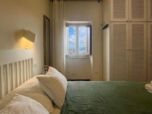 a bedroom with a bed with a window at Aria di Collina - Isola d'Elba in Porto Azzurro