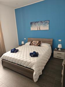 een slaapkamer met een groot bed met een blauwe muur bij La casa di Alessandro in Noto