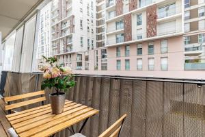 a wooden table on a balcony with a vase of flowers at GuestReady - Bright getaway near la Défense in Nanterre